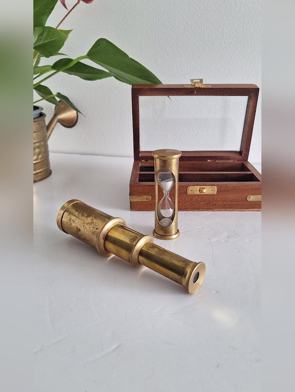 Glass and brass telescope and hourglass